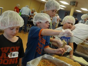 Youth packing meals for children in need